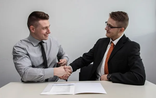 A clinic and GP shaking hands directly